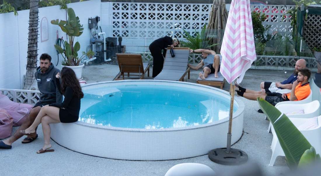 Heated plunge pool with pink striped umbrellas and sun loungers